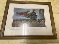 Frontal view of the framed print showing the Hudson steam engine locomotive in motion, with steam and surrounding scenery.