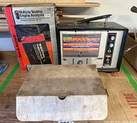Multiple Testing Engine Analyzer with instruction manual and closed accessory box on table.