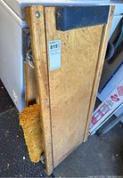 Wooden floor dolly showing top with padded black end and seller price label on surface