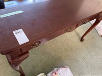 Top and front view of a wooden hall table with two drawers and metal handles, showing surface scratches and curved legs.