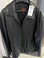 Full front view of men's black leather jacket hanging on a hanger.