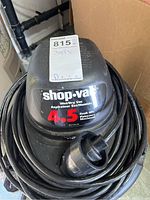 Top view of Shop-Vac motor housing showing branding, 4.5 peak HP label and power cord coiled around it.