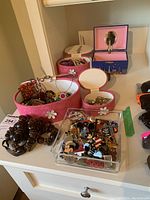 Wide shot of the jewelry containers and costume jewelry pieces on a white cabinet