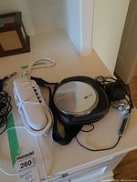 Photo showing the Panasonic SL-CT810 MP3 player with its carrying case alongside a white corded phone.