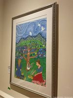 Framed drawing displayed on wall, showing the full composition including two female figures, tree with birds, and comprehensive background.