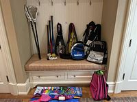 Overview of bench displaying rackets, bats, balls, gloves, lacrosse sticks, bags, backpacks and kites