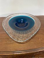 Top angle showing the deep royal blue center and the clear glass bubble edge of the triangular fruit bowl.