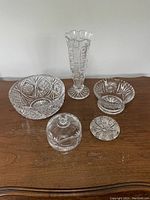Top view of five assorted Czech crystal pieces including vase, bowls, covered dish, and plate.