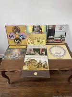 Photo of 7 vinyl record album covers spread out on wooden table showing various artists and genres from 1960s era.