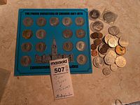 Full view of the blue display board with the 20 commemorative medallions showing portraits of Canadian Prime Ministers from 1867 to 1970 plus a pile of assorted Canadian coins and tokens, some loose and some in plastic capsules.