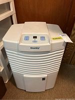 Full frontal image showing the white Danby dehumidifier with vented panel and top control section in a room.