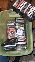 Plastic bin containing assorted cassette tapes with visible albums and cases