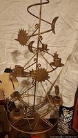 Metal spiral Christmas tree with sun, moon, and star shapes for candle holders.
