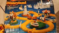 Boxed Disneyland Play Set showing layout of train track, rides, and characters on packaging