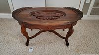 Full view of antique wooden coffee table showing carved eagle centerpiece and carved legs