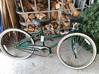 Full side view of green Murray Monterey girls bicycle showing frame, wheels, and seat with white-walled tires and rust on parts.