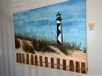 Full view of the beach scene canvas print showing the lighthouse, sand dune, and sea grass in a realistic painting style.