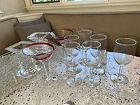 Overview of all stemware glasses and glass candlesticks on a speckled countertop.