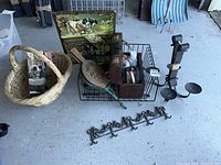 Full view of vintage items including landline phone, bellows, dog picture, shoe care case, basket, and metal wall hook rack on a concrete floor