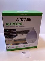 Box of Aircare Aurora Ultrasonic Cool Mist Humidifier highlighting features such as 1-gallon capacity, 12-hour run time, essential oil diffuser, multicolor LED nightlight, and suitable for up to 750 sq. ft.