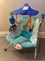 Front view of baby bouncer showing seat, canopy, and hanging toys