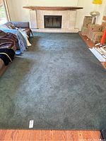 Full view of the large dark grey/charcoal rectangular area rug placed on a wooden floor in living room setting.