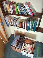 Books on wall-mounted shelves arranged standing upright with various titles visible