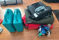 Full lot overview showing water containers, sleeping bags, cushions, propane canisters, camping lantern and accessories.