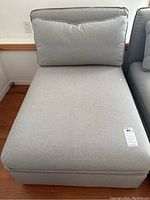 Front view of grey upholstered chaise lounge with back and seat cushions