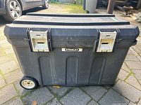 Front view of the black Stanley construction tote showing latches and wheel base.