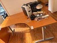 Top and side view of the office desk showing wood finish top with office items on it and metal legs.