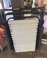 Folded zero gravity lounge chair showing metal frame and mesh fabric secured with elastic cords.