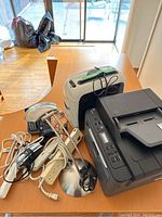 Full lot showing Brother printer/copier, shredder, telephone, desk lamp, power cords and extension power strip on a wooden floor near sliding glass door.