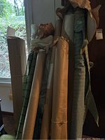 Several upright rolls including green stripe, white, and blue stripe fabrics