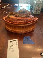 Full shot of the rabbit dish on the table with auction card