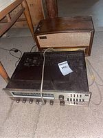 Stereo receiver and Zenith radio side by side on carpeted basement floor