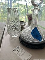 Photo showing the decanter and vase next to each other on a table with natural light, revealing clear diamond cut patterns on both.