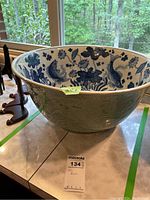 Overall view of the bowl showing exterior celadon glaze and embossed floral relief
