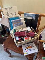 Overview of black canvases, white canvases in different sizes, spiral-bound mixed media paper, and a plastic basket with art supplies