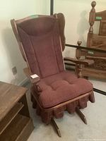 Photo showing the wooden rocker chair with brown corduroy cushions from a front angle.