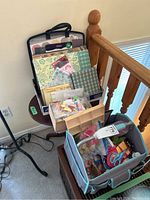Photo of a round table holding an open craft bag filled with papers, sticker packs, and various craft items including scissors and embellishments.