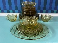 Full lot showing stacked plates, cups arranged around, displayed on blue surface.