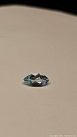Sky blue topaz marquis cut gemstone, capturing top and side facets to show shape and color.