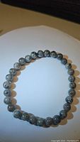 Photo of natural yooperlite bracelet beads arranged in a circle on a white background showing the overall appearance and bead detail.