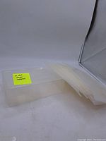 Stack of clear plastic shoe storage containers, showing their rectangular shape and transparent material with loose lids.