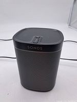 Front-top view showing 'SONOS' branding and top control buttons of the speaker.