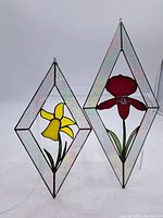 Full view of both diamond-shaped stained glass panels with floral designs.