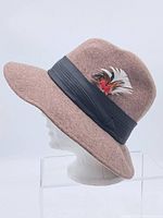Side view of the brown felt hat on a foam head, showing the wide brim and the black pleated band.