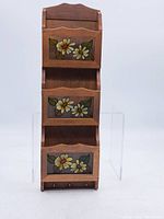 Front view of the full wooden wall-mounted organiser showing three compartments with floral panels.