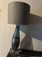 Photo of the teal and silver/grey table lamp with a grey fabric shade, showing full lamp and details on the base and shade.